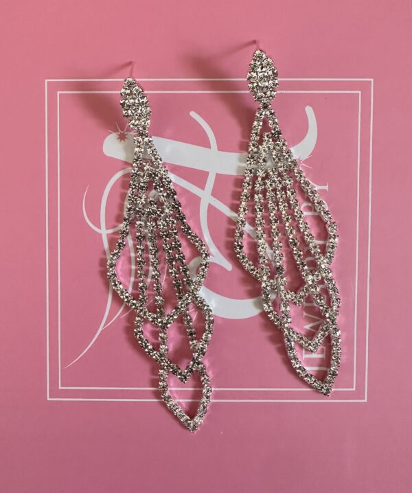 a pair of earrings on a pink background