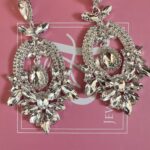 a pair of earrings on a pink box