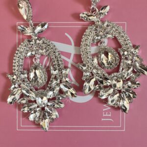 a pair of earrings on a pink box