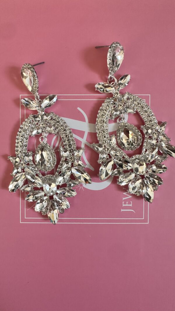 a pair of earrings on a pink box