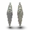 a pair of earrings with large crystals with Watts Towers in the background
