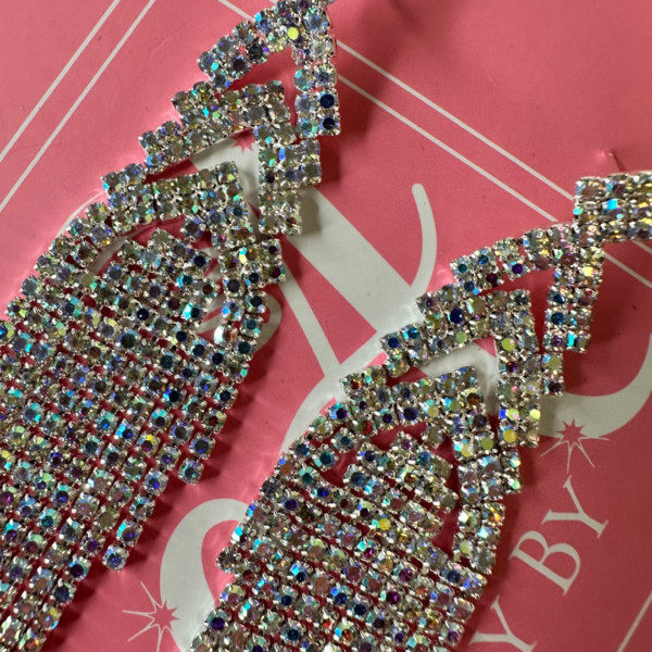 a pair of earrings on a pink background